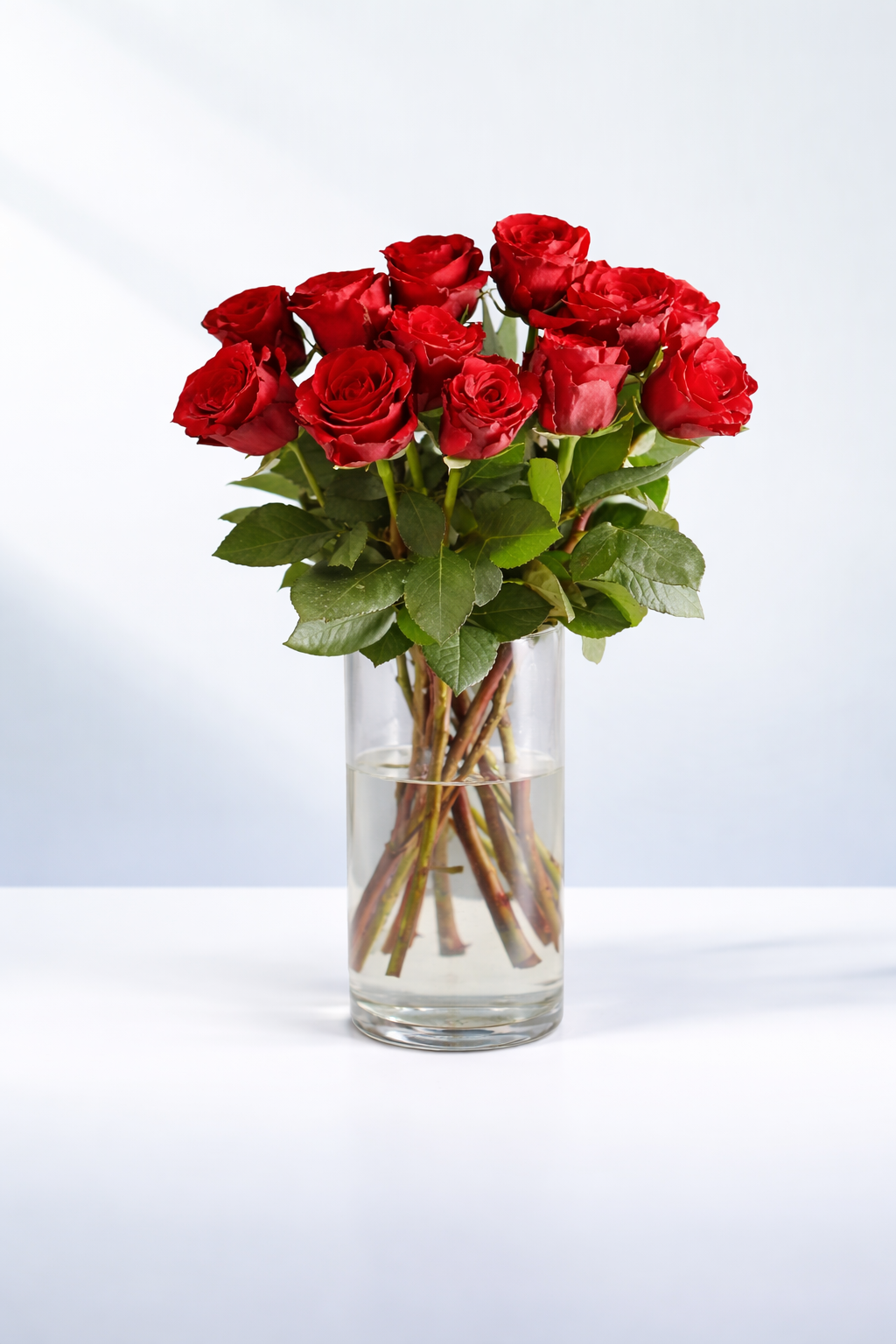 Valentine’s Day arrangement of 12 long-stem red roses in a clear glass vase, approximately 50cm in length, vase included.