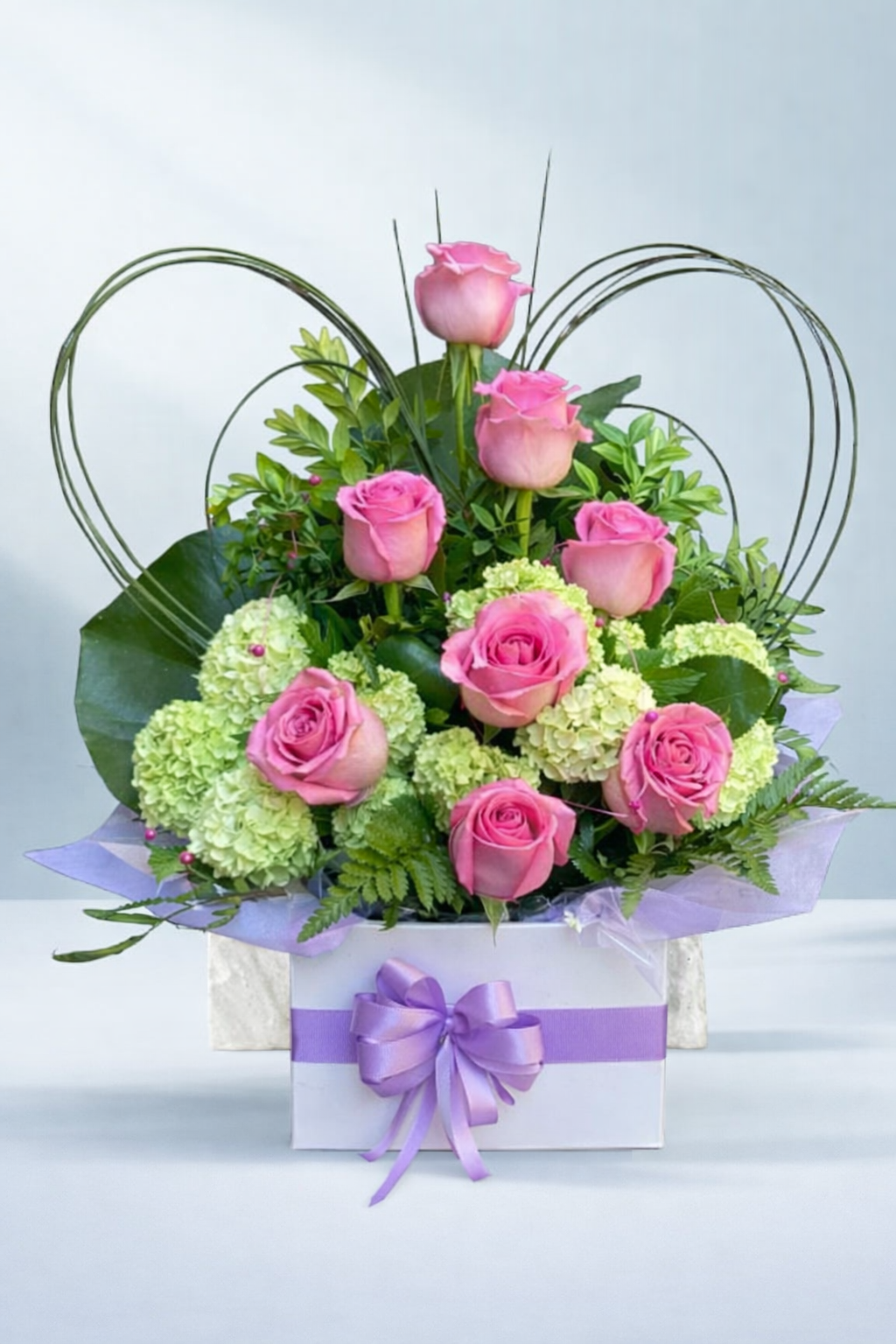 Pretty pink rose and green hydrangea floral arrangement in a white box with a lilac ribbon, created by Emflowerment Florist in Croydon and available for Melbourne delivery.