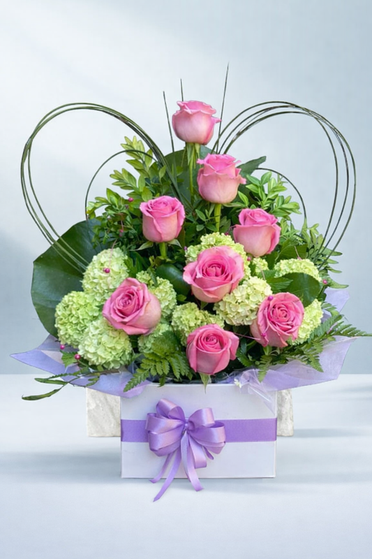 Pretty pink rose and green hydrangea floral arrangement in a white box with a lilac ribbon, created by Emflowerment Florist in Croydon and available for Melbourne delivery.