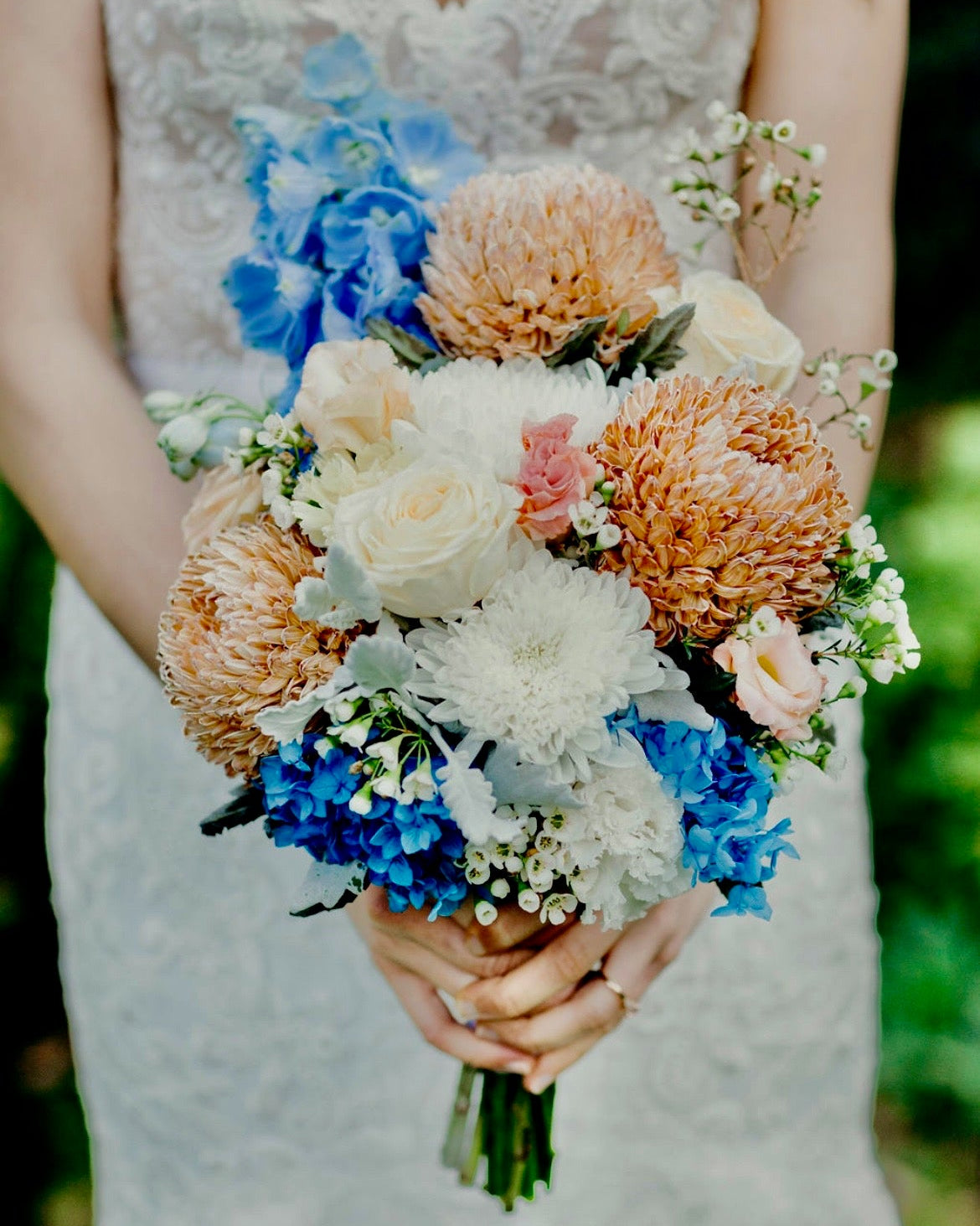 bride holding a colourful bouquet with blue accents from emflowerment croydon.
