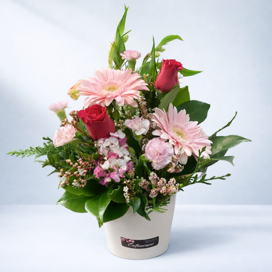 Bouquet of flowers in a white container on a light blue background from Emflowerment florist in Croydon