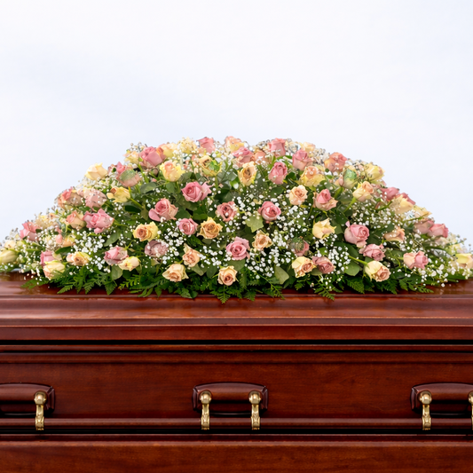 Wooden casket with a floral arrangement on a white background